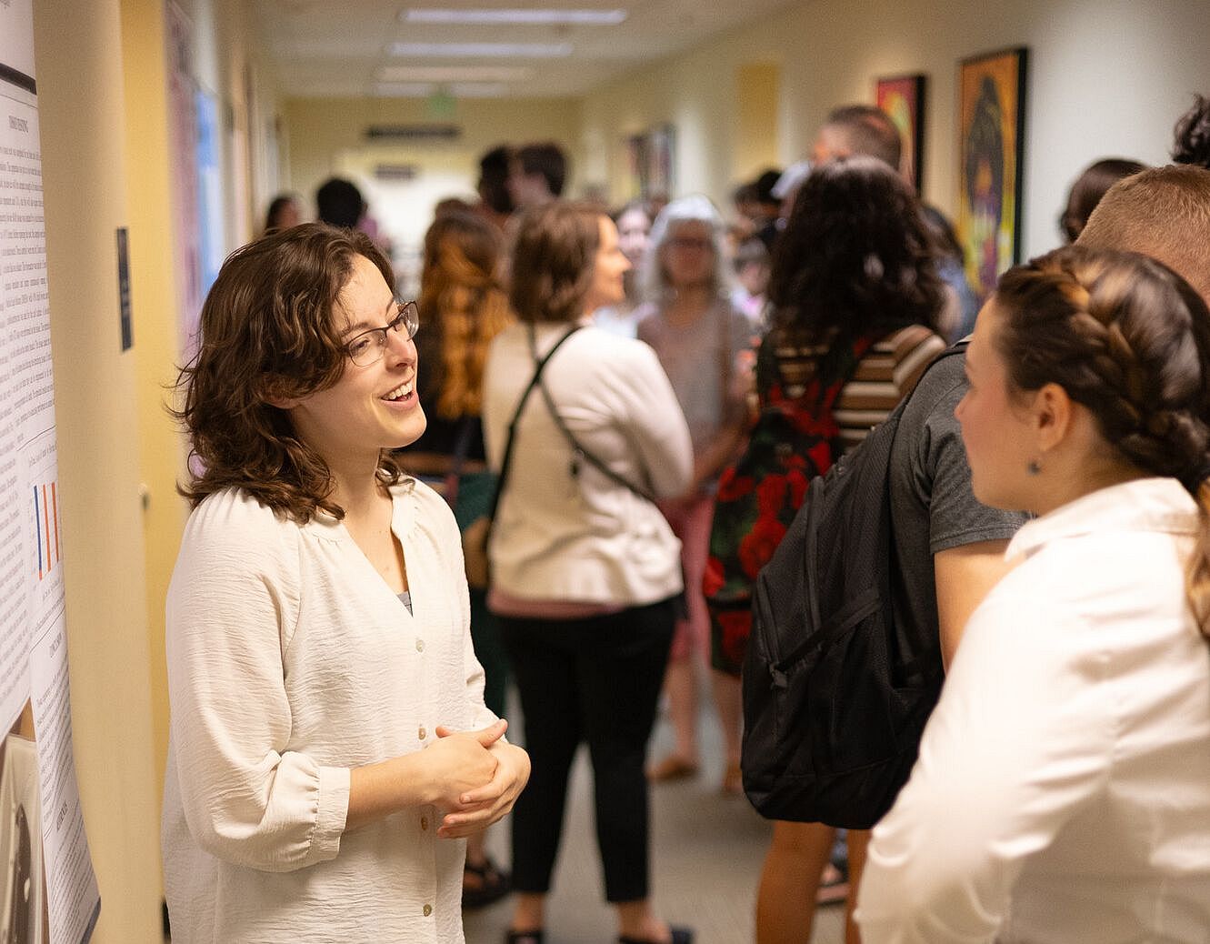 Student presenting their poster to symposium attendees