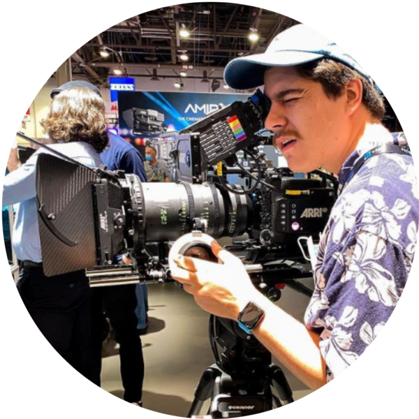 A man standing behind a film camera.