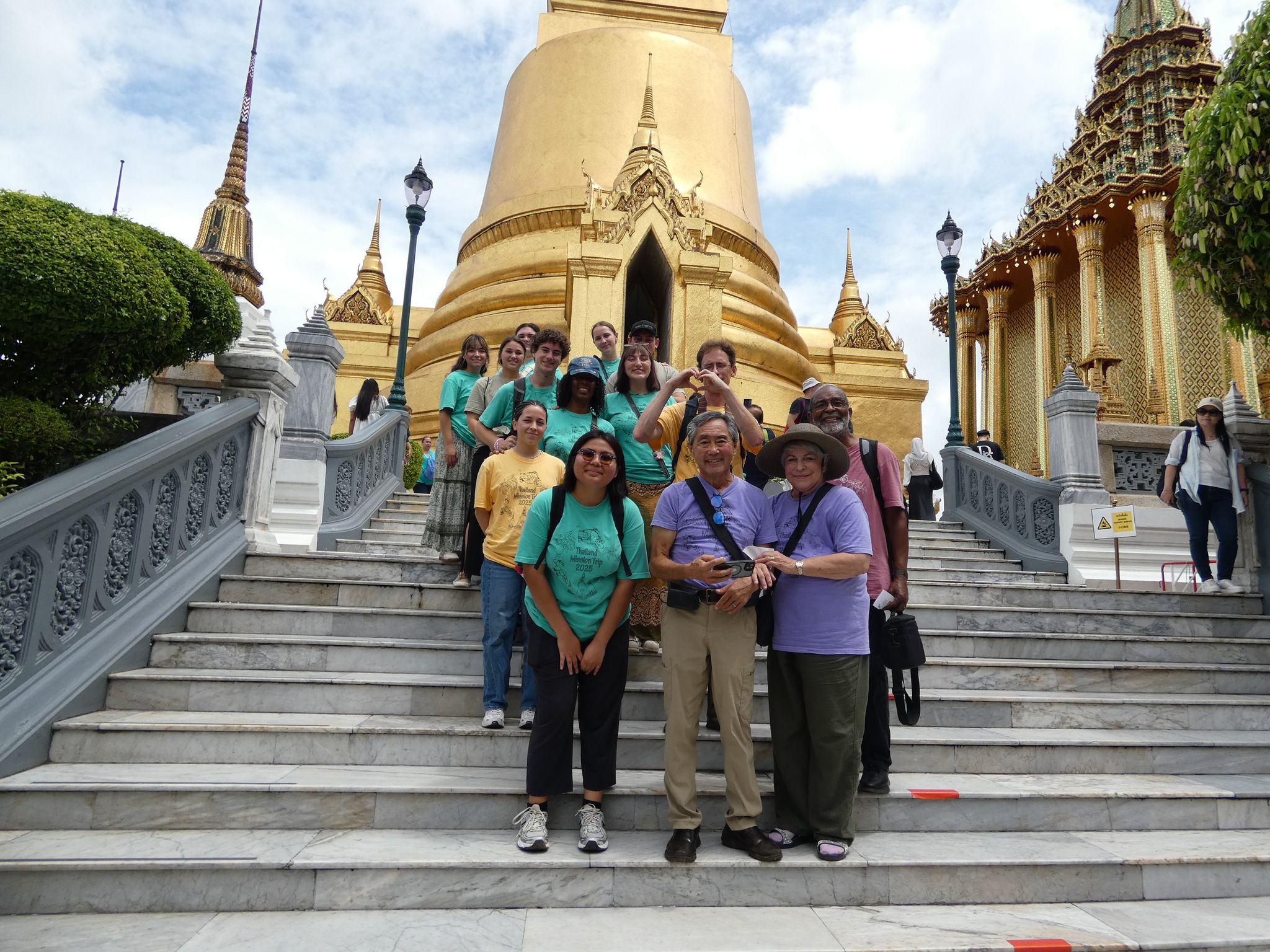 Group photo of everyone in front of the Temple of the Emerald Buddha in Bangkok, Thailand