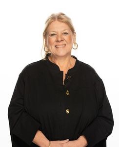 Professional headshot portrait of Julie Hunt, a blonde woman wearing a black button-down shirt.