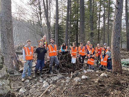 Orange Vested volunteers posing for a group photo after saving a barn from flooding