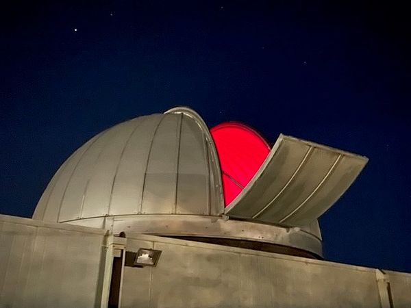 The exterior view of the observatory with the dome open from the outside observation deck. 