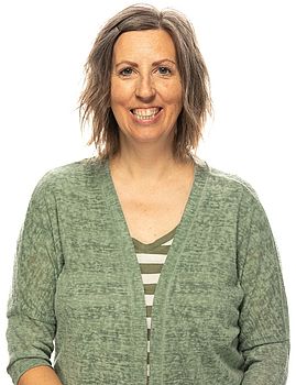 Headshot photo of Joan Wright standing in front of a white background.