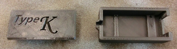 3d-printed case with cap on left and box on right.