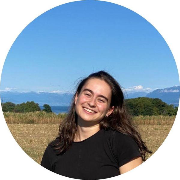 Photograph of tutor Ana standing in a field with blue sky.