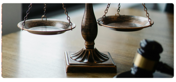 Scales of justice and gavel sit on a desk