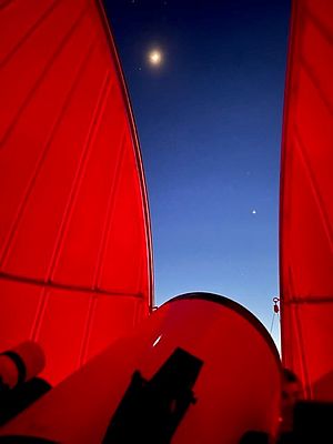 A view from inside the observatory looking along the top of the telescope toward the moon.