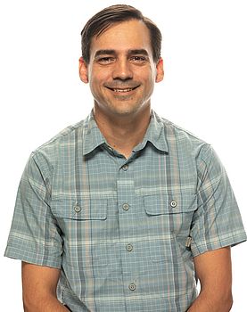 A headshot photo of Richard Thomas standing in front of a white background.