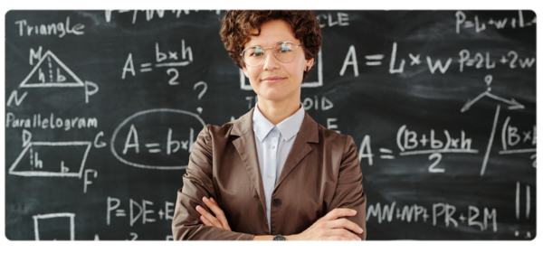 A physics graduate stands in front of a blackboard full of equations