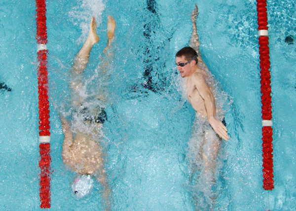 Two swimmers pass each other during lap swim.