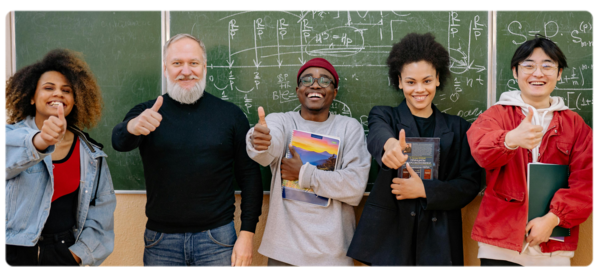 Highschool students stand in front of a blackboard with their math teacher with thumbs up after completing a problem on the board