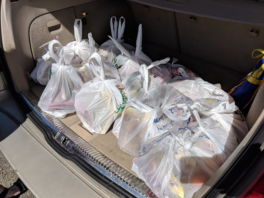 The back of a car is packed with bagged lunches for Lincoln High School students