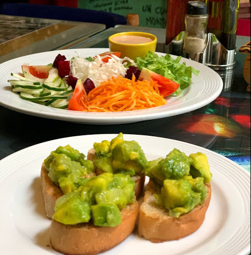 Colorful tropical foods on two white plates.