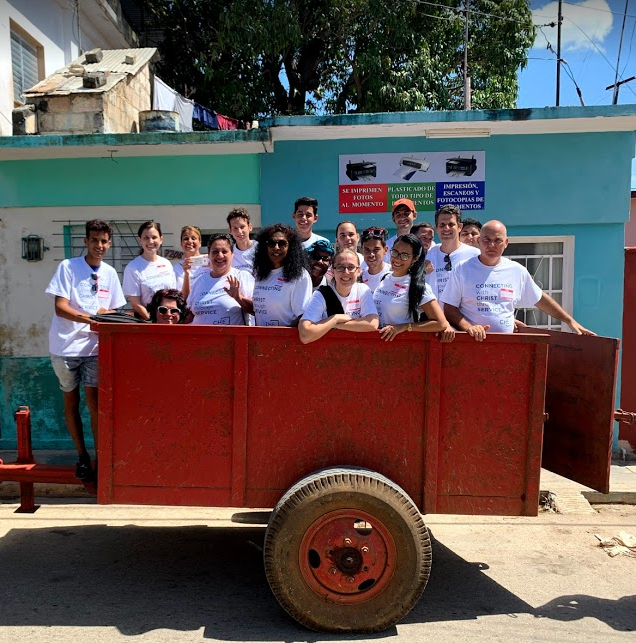 Group of people in matching shirts in red trailer. 