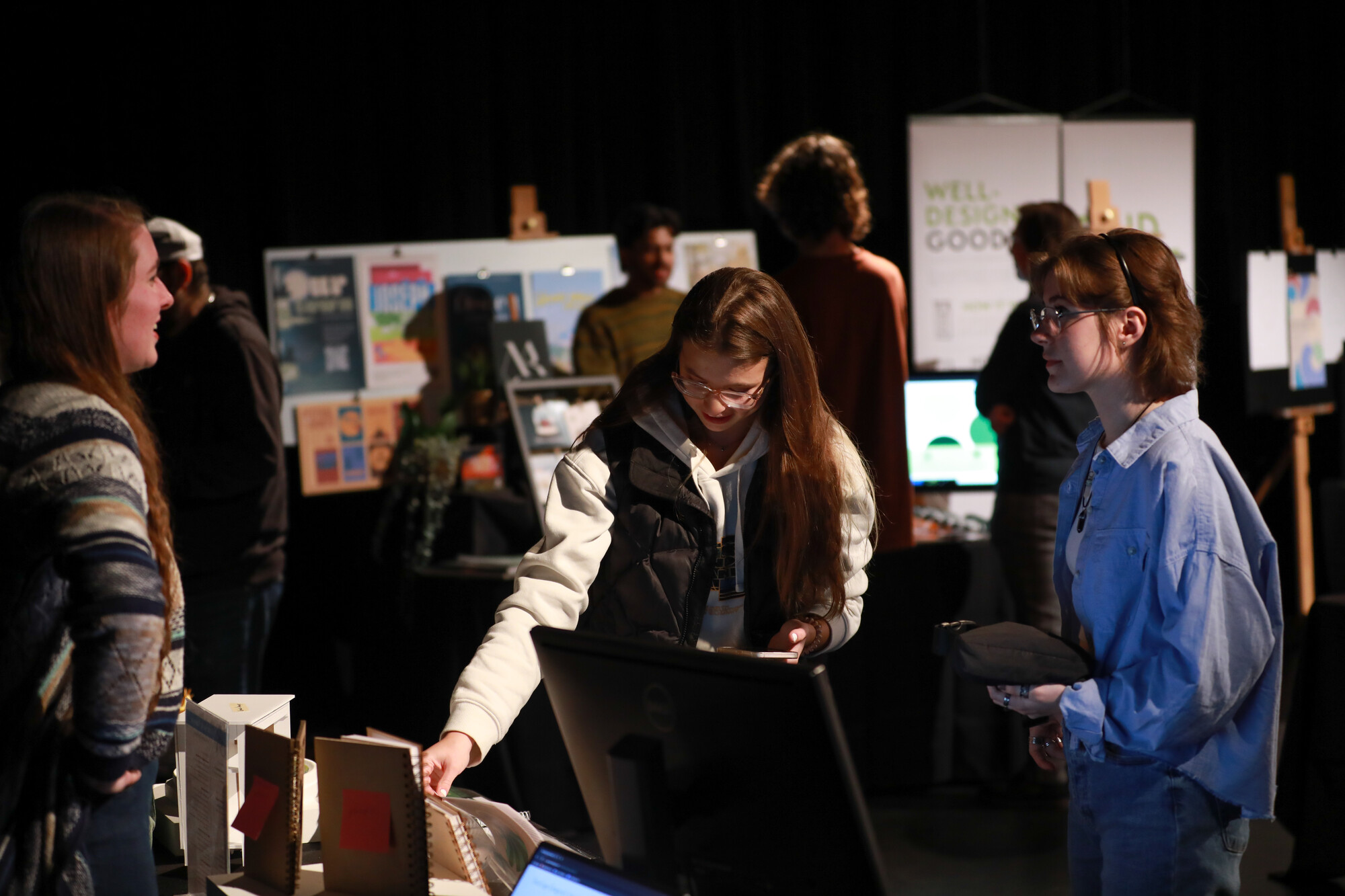 Students explore a design booth with examples of student work.